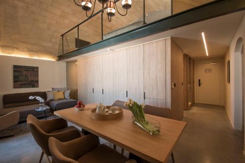 a living room with a wooden table and chairs at Cugo Gran Macina Malta in Senglea