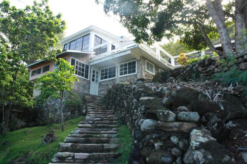 un camino de piedra que conduce a una casa con una pared de piedra en Posada Rock-stone, en Providencia