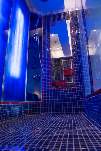 a blue bathroom with a mirror and a shower at Silvia's Apartment in Voluntari