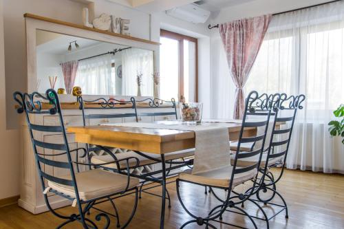 uma sala de jantar com mesa e cadeiras em Silvia's Apartment em Voluntari