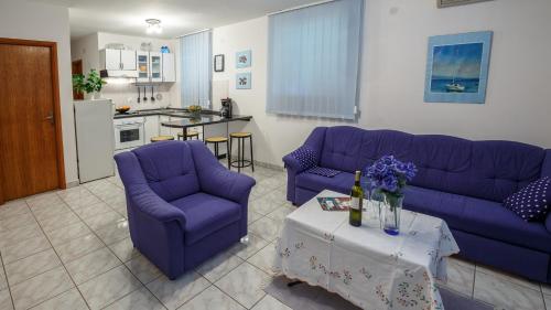 a living room with two purple couches and a table at Josephine in Njivice