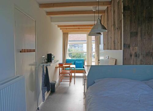 sypialnia z łóżkiem, stołem i krzesłami w obiekcie Studio Zilt w mieście Vlissingen