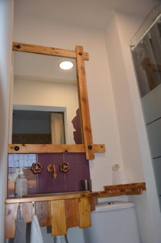 a mirror above a toilet in a bathroom at Os Piratas in Charneca