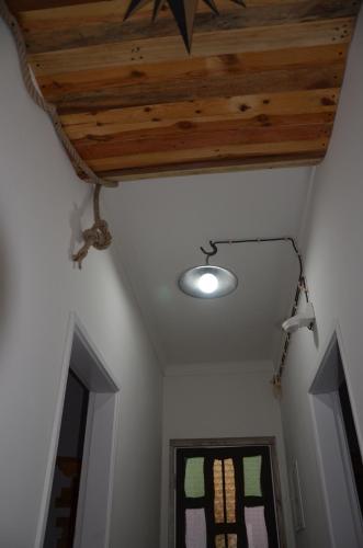 a room with a wooden ceiling with a light and a window at Os Piratas in Charneca