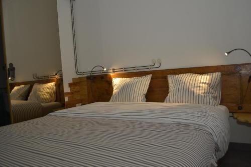 a bed with striped sheets in a bedroom at Os Piratas in Charneca