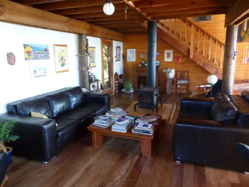 a living room with a leather couch and a coffee table at The Old Slaughterhouse Traveller's Lodge in Hector