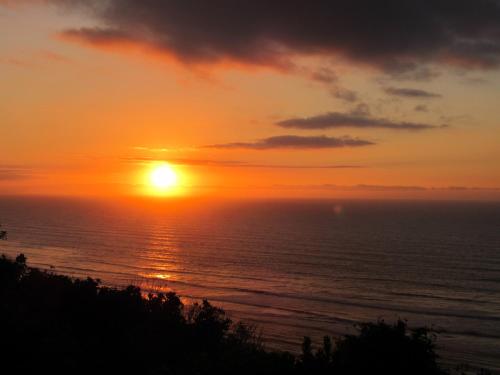 a sunset over the ocean with the sun setting at The Old Slaughterhouse Traveller's Lodge in Hector