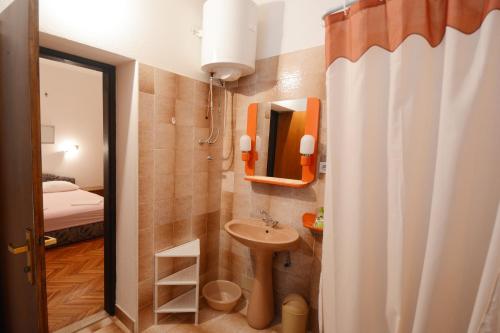 a small bathroom with a sink and a mirror at Apartments Ante in Omiš
