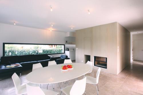a dining room and living room with a white table and chairs at Le 27 in Malaucène