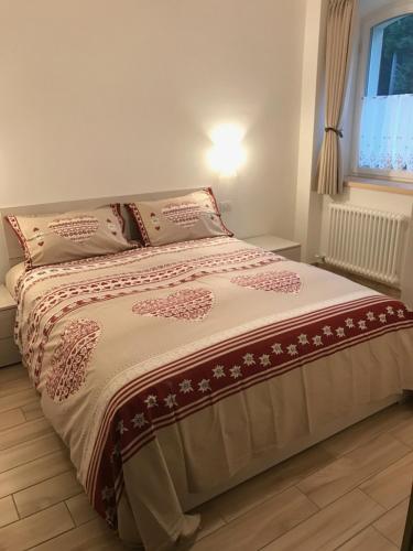 a bed in a bedroom with a bedspread and pillows at Genzianella Molveno-Andalo in Molveno