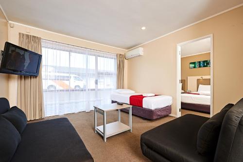 una camera d'albergo con due letti e un divano di Auckland Airport Lodge ad Auckland