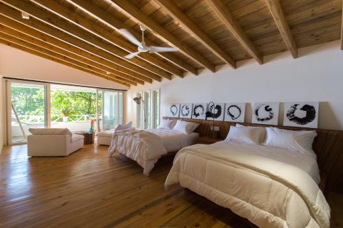 a bedroom with two beds and a ceiling fan at Ibagari Boutique Hotel in Roatán