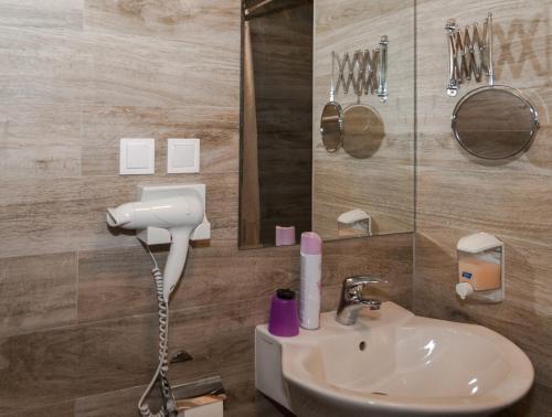 a bathroom with a sink and a mirror and a shower at AnVa House in Budapest
