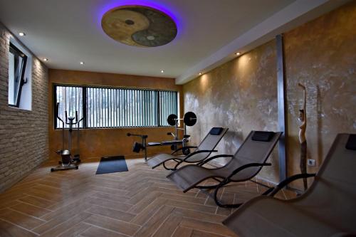 a gym with chairs and a purple light on the ceiling at Art Spa Villa Gal in Velingrad