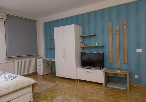 a living room with a television and a white cabinet at Apartments Parlament in Belgrade