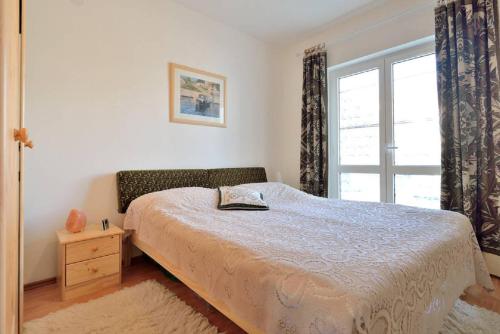 um quarto com uma cama e uma grande janela em IVA APARTMENTS&BIKEs em Pula