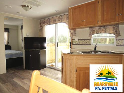 a kitchen with a sink and a refrigerator at Boardwalk RV Rental (Site #14) in Cavendish