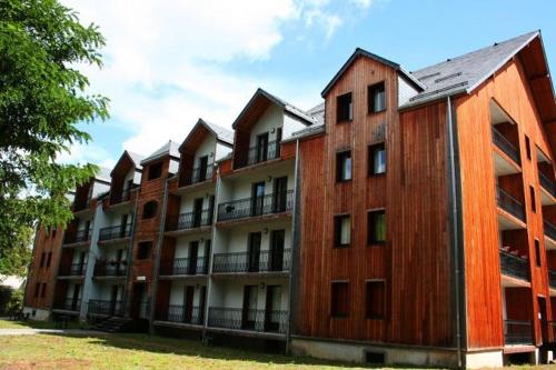 ein Apartmenthaus mit vielen Fenstern an der Seite in der Unterkunft Appartement T2 Jardins de Ramel in Luchon