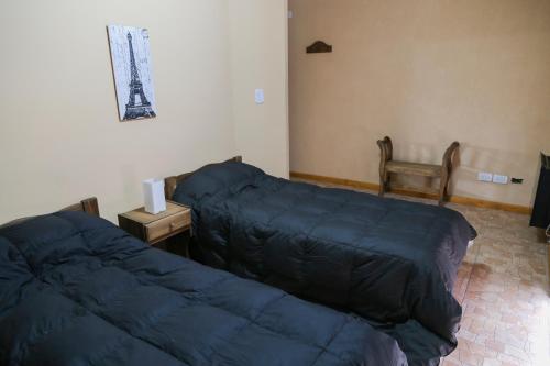 a bedroom with two beds and a nightstand and a bed sidx sidx at Singlar Consultora in Malargüe