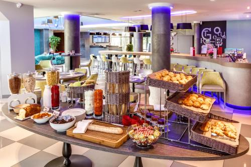a table with baskets of bread and other food at Novotel Orléans Saint Jean de Braye in Saint-Jean-de-Braye