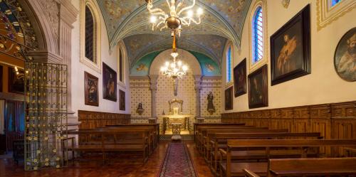a church with wooden pews and a chandelier at Hotel Museo Palacio de San Agustin in San Luis Potosí