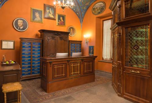 an orange room with a cabinet and some pictures on the wall at Hotel Museo Palacio de San Agustin in San Luis Potosí