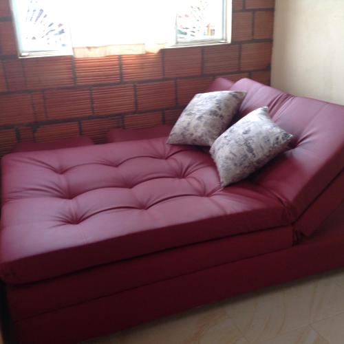 a red couch with two pillows on it at Casa finca El Girasol in Guayabal de Síquima