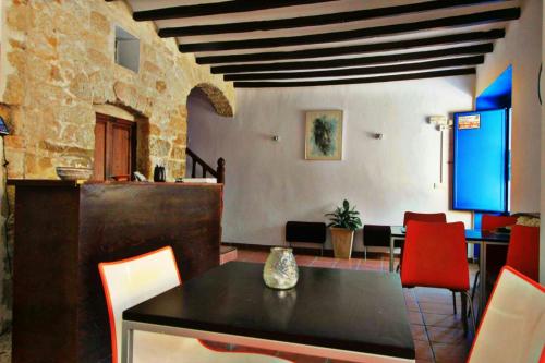 a dining room with a table and red chairs at La Trancada in Tabarca