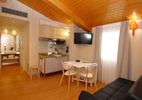 a kitchen and living room with a table and chairs at Hostal riMboMbin in Burgos