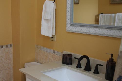 a bathroom with a sink and a mirror at Castle by the Shore in Ocho Rios
