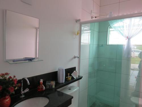a bathroom with a sink and a glass shower at Recanto Dos Gansos in Pardinho