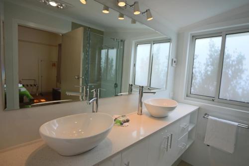 uma casa de banho com 2 lavatórios e um espelho grande em Moonah Central Apartments em Hobart