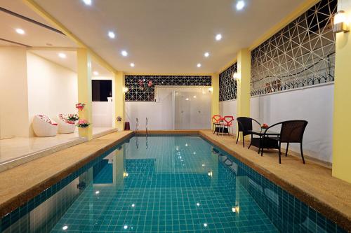 a swimming pool with a table and chairs next to it at Happy Hostel in Pattaya Central