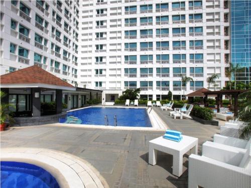 a swimming pool in front of a large building at Quest Serviced Residences in Cebu City