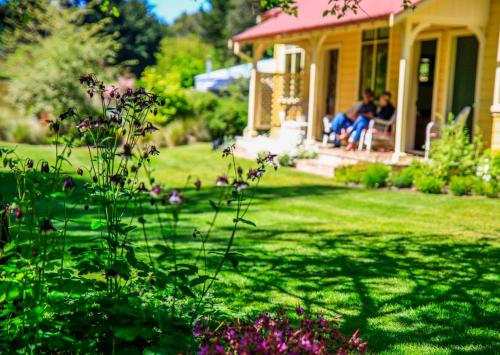 two people sitting on the porch of a house at Leader Valley Cottage - A Tranquil Retreat For Two in Mendip Hills