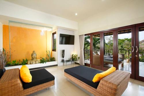 a living room with two couches and a balcony at Villa L'Orange Bali in Keramas