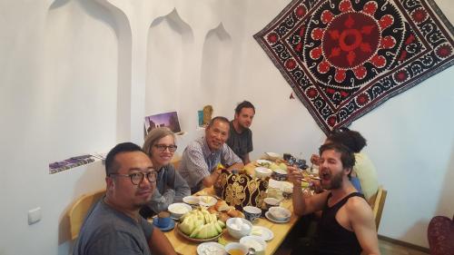a group of people sitting around a table eating food at Amir Hostel in Samarkand