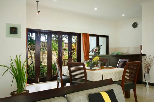 a living room with a dining room table and chairs at Villa L'Orange Bali in Keramas