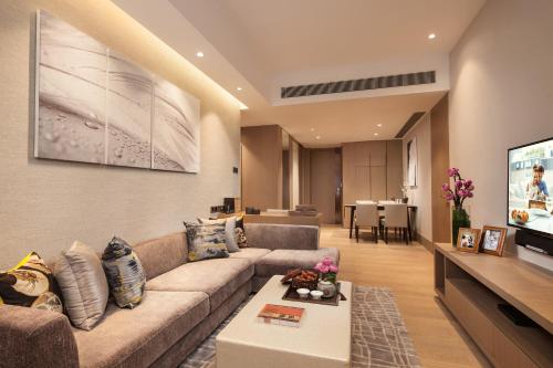a living room with a couch and a tv at Ascott Raffles City Shenzhen in Shenzhen