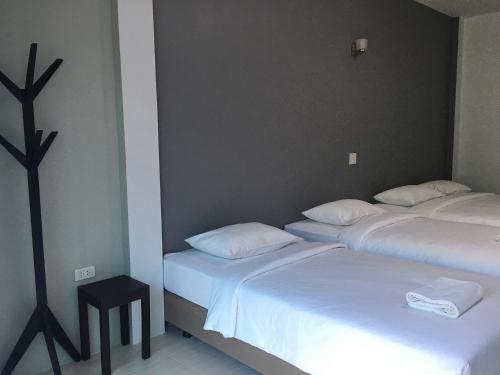 two beds in a room with white sheets at Ban Krut Resort in Ban Krut