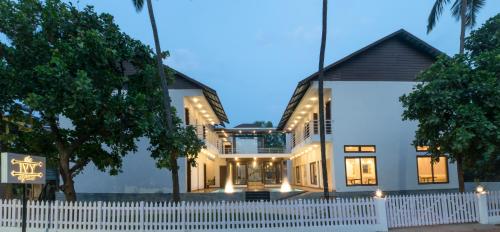 a house with a white fence in front of it at The Ivy Anjuna in Anjuna
