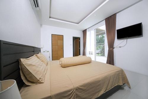 a bedroom with a large bed with a flat screen tv at VILLA CHELONI 2 BEDROOMS in Kamala Beach