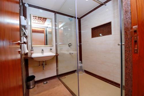 a bathroom with a glass shower and a sink at Southern Star,Davangere in Dāvangere