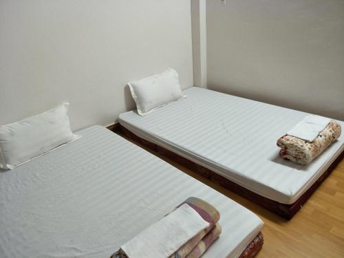 two beds in a small room with white walls at Ngan Ha Homestay in Ha Giang