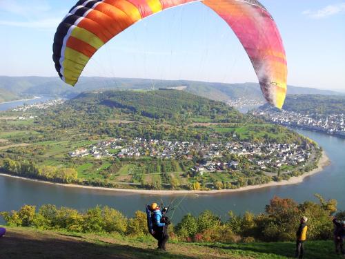a person flying a parachute over a river at Ferienwohnungen Gronen in Boppard