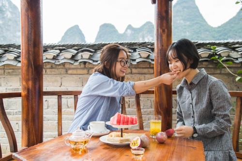 two women sitting at a table eating food at Leisure Courtyard Hotel Yangshuo in Yangshuo