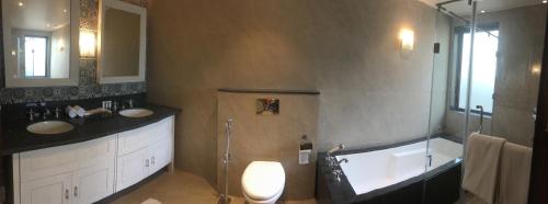 a bathroom with two sinks and a tub and a toilet at The Ivy Anjuna in Anjuna