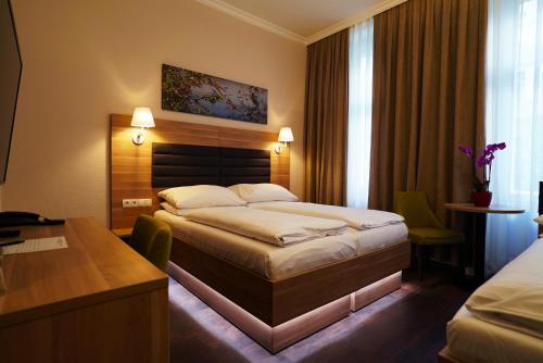 a hotel room with a bed and a desk at Hotel Marc Aurel - Vienna City Center in Vienna