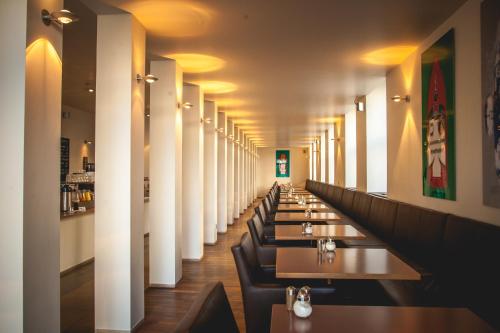 une rangée de tables et de chaises dans un restaurant dans l'établissement Hotel Alexander, à Wiesbaden