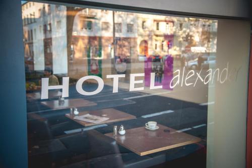 a window of a hotel room with tables and a sign at Hotel Alexander in Wiesbaden